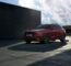 a red suv parked in front of a building